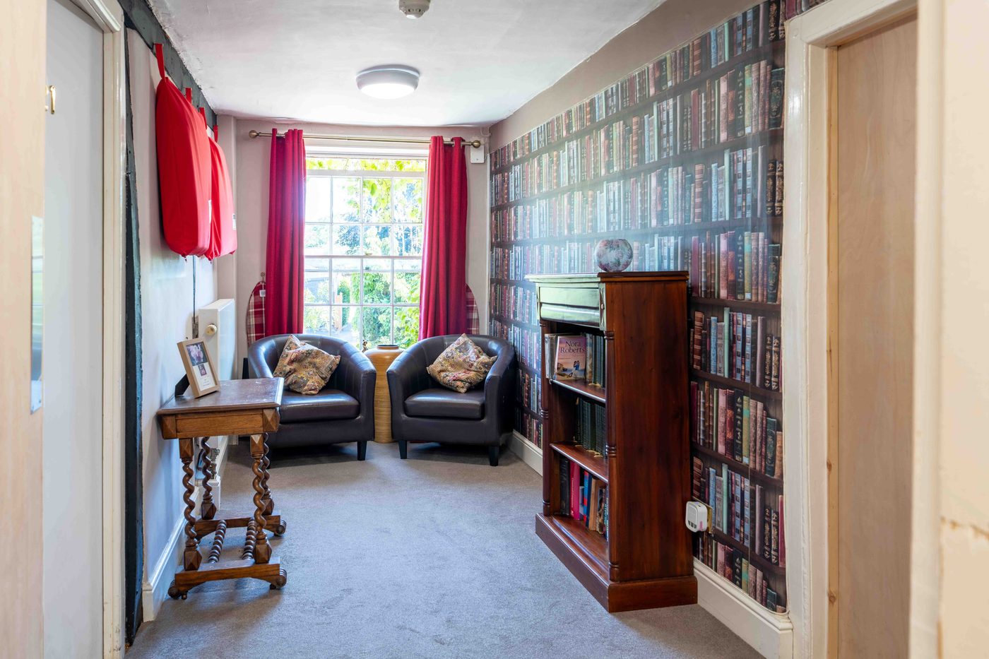 A resident and a carer together in a quiet, sunlit room at Little Brook House